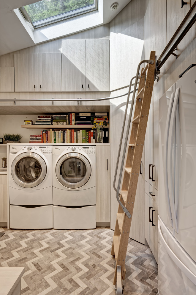 Inspiration for a small modern u-shaped utility room in New York with an undermount sink, flat-panel cabinets, light wood cabinets, quartz benchtops, white walls, porcelain floors, a side-by-side washer and dryer, multi-coloured floor, white benchtop and vaulted.