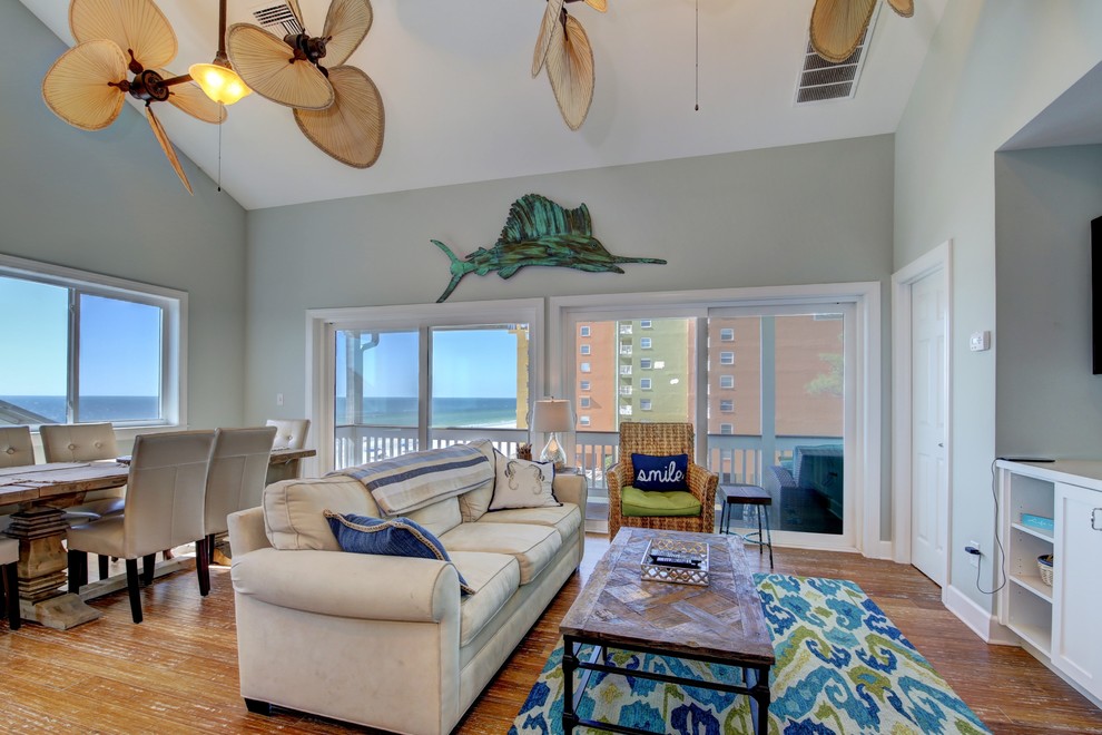 Photo of a mid-sized beach style open concept family room in Tampa with blue walls, a wall-mounted tv, bamboo floors and no fireplace.