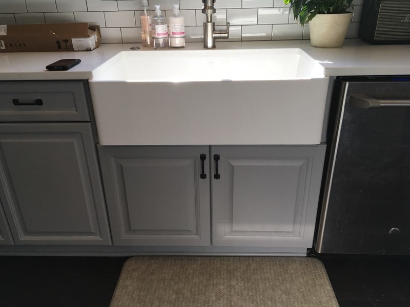 Inspiration for a transitional dark wood floor and brown floor kitchen remodel in Atlanta with a farmhouse sink, raised-panel cabinets, quartzite countertops, white backsplash, subway tile backsplash, stainless steel appliances and white cabinets