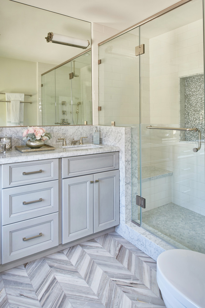 This is an example of a mid-sized transitional master bathroom in Los Angeles with shaker cabinets, grey cabinets, white tile, marble floors, marble benchtops, a corner shower, white walls and a drop-in sink.
