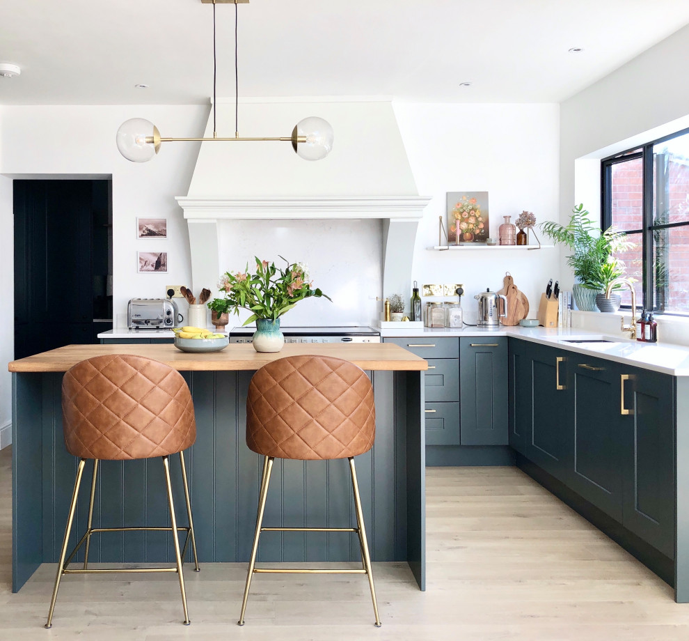 Mid-sized transitional l-shaped open plan kitchen in Other with an undermount sink, shaker cabinets, blue cabinets, quartzite benchtops, white splashback, engineered quartz splashback, stainless steel appliances, laminate floors, with island, beige floor and white benchtop.