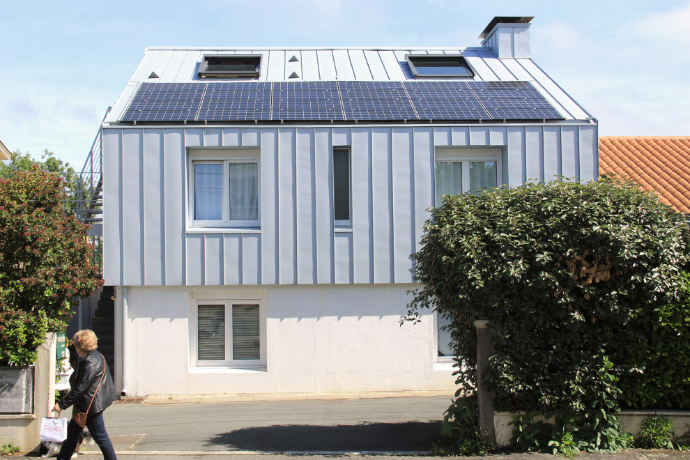 Mittelgroßes, Dreistöckiges Modernes Reihenhaus mit Metallfassade, grauer Fassadenfarbe, Satteldach, Blechdach, grauem Dach und Wandpaneelen in Nantes
