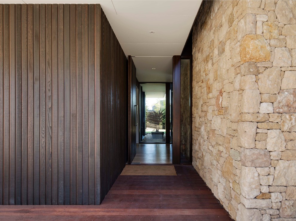 Photo of a large front door in Melbourne with brown walls, dark hardwood floors, a pivot front door and a dark wood front door.