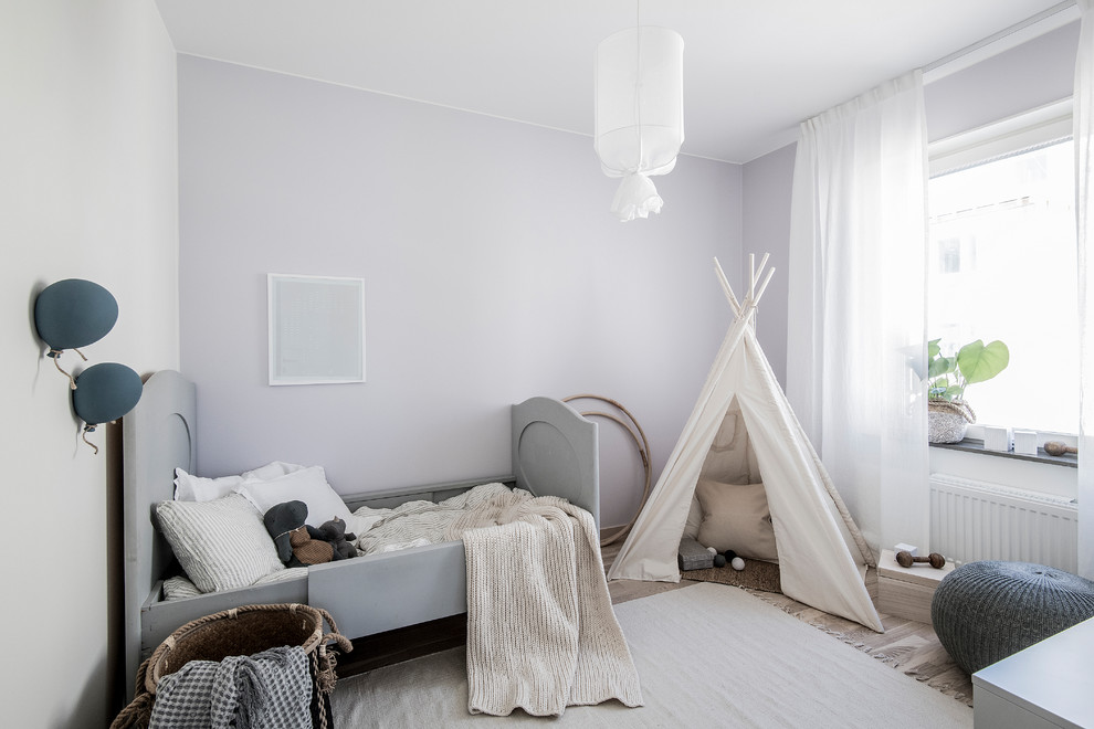 This is an example of a mid-sized scandinavian kids' bedroom for kids 4-10 years old in Stockholm with purple walls.