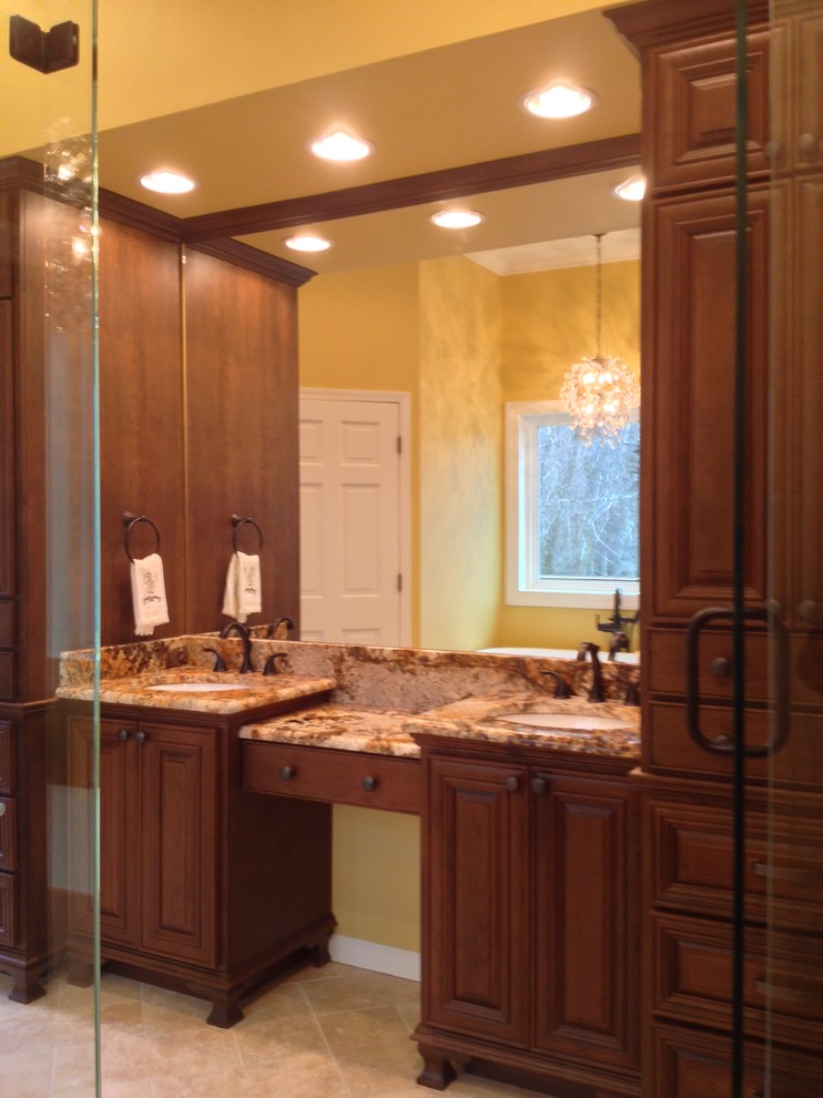 This is an example of a large traditional master bathroom in Charlotte with an undermount sink, furniture-like cabinets, medium wood cabinets, granite benchtops, a freestanding tub, an open shower, a two-piece toilet, beige tile, stone tile, beige walls and travertine floors.