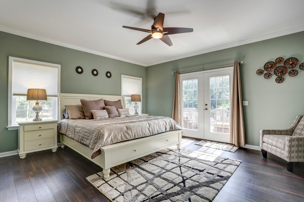 Traditional master bedroom in Other with green walls, dark hardwood floors and brown floor.