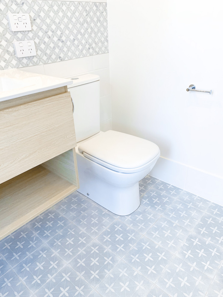 Small 3/4 wet room bathroom in Brisbane with a wall-mount toilet, multi-coloured tile, ceramic tile, ceramic floors, an integrated sink, multi-coloured floor, an open shower, a niche, a floating vanity and decorative wall panelling.