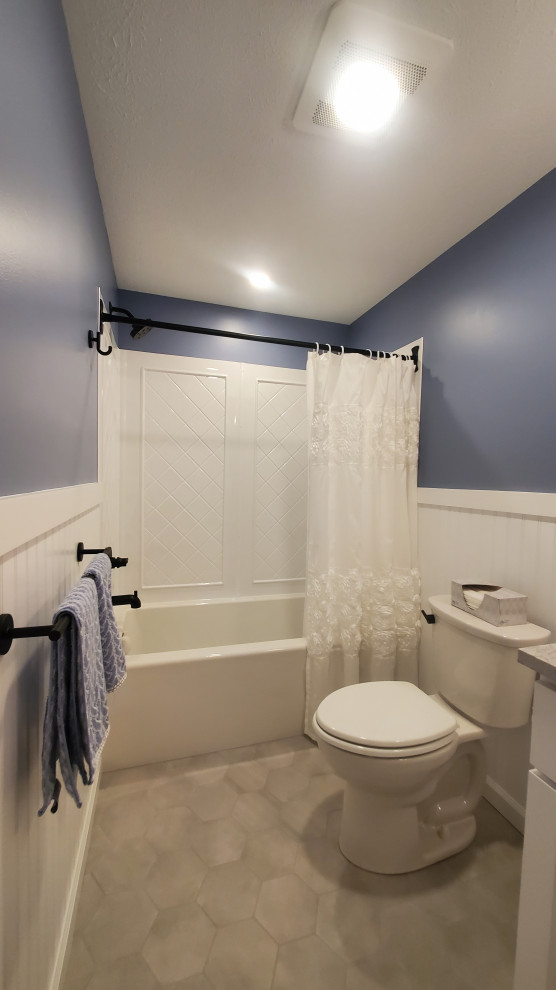 Идея дизайна: маленькая ванная комната в классическом стиле с фасадами в стиле шейкер, белыми фасадами, ванной в нише, душем над ванной, унитазом-моноблоком, белой плиткой, керамической плиткой, синими стенами, полом из керамической плитки, врезной раковиной, столешницей из искусственного кварца, серым полом, шторкой для ванной, серой столешницей, тумбой под одну раковину, встроенной тумбой и стенами из вагонки для на участке и в саду