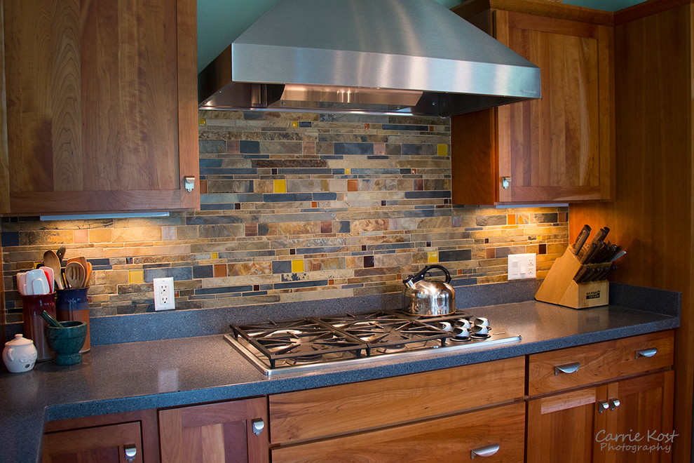 Example of a mid-sized transitional l-shaped open concept kitchen design in Milwaukee with shaker cabinets, medium tone wood cabinets, quartzite countertops, multicolored backsplash, mosaic tile backsplash, stainless steel appliances and an island