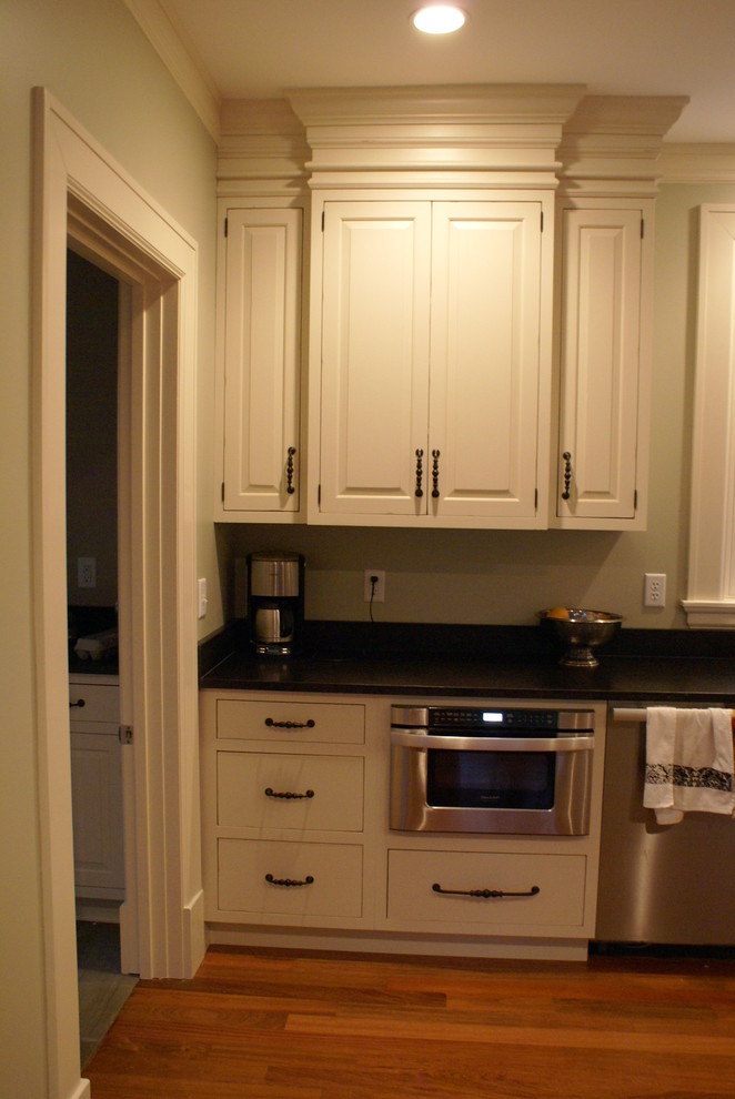 Inspiration for a rustic medium tone wood floor kitchen remodel in Chicago with a farmhouse sink, raised-panel cabinets, white cabinets, granite countertops, stainless steel appliances and an island