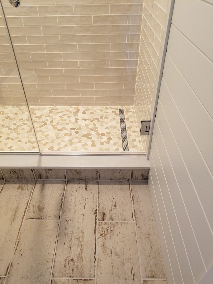 Photo of a mid-sized country 3/4 bathroom in Milwaukee with ceramic floors, glass tile, grey walls and a hinged shower door.