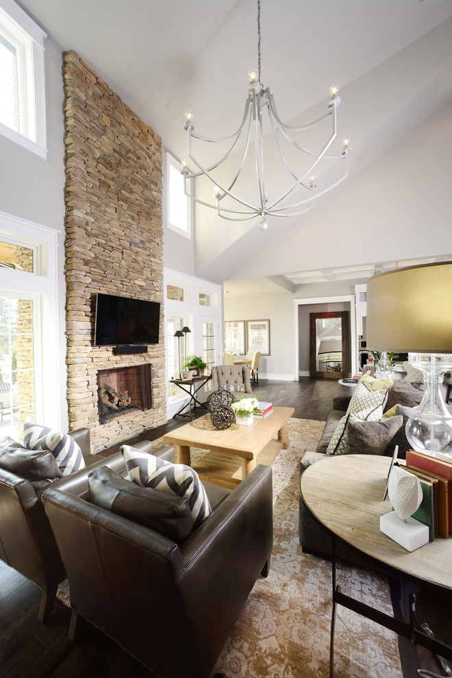 Design ideas for a large transitional open concept living room in Other with grey walls, dark hardwood floors, a standard fireplace, a stone fireplace surround and a wall-mounted tv.