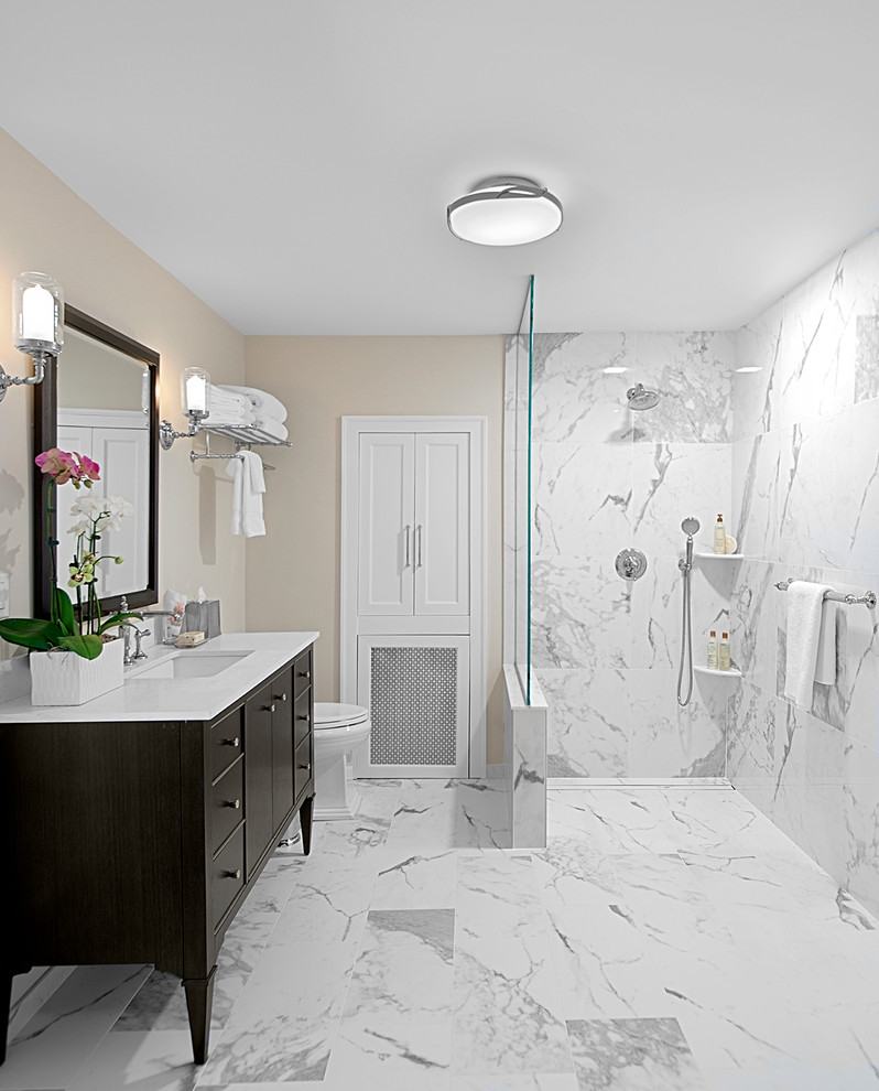 Photo of a mid-sized transitional 3/4 bathroom in Chicago with flat-panel cabinets, dark wood cabinets, a curbless shower, white tile, stone slab, beige walls, marble floors, an undermount sink, quartzite benchtops, white floor, an open shower and white benchtops.