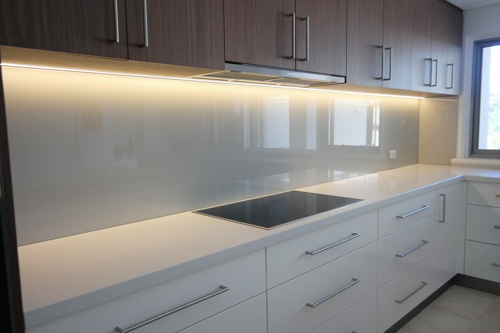 Photo of a mid-sized modern galley eat-in kitchen in Perth with a triple-bowl sink, raised-panel cabinets, medium wood cabinets, quartz benchtops, white splashback, glass sheet splashback, stainless steel appliances, bamboo floors and with island.