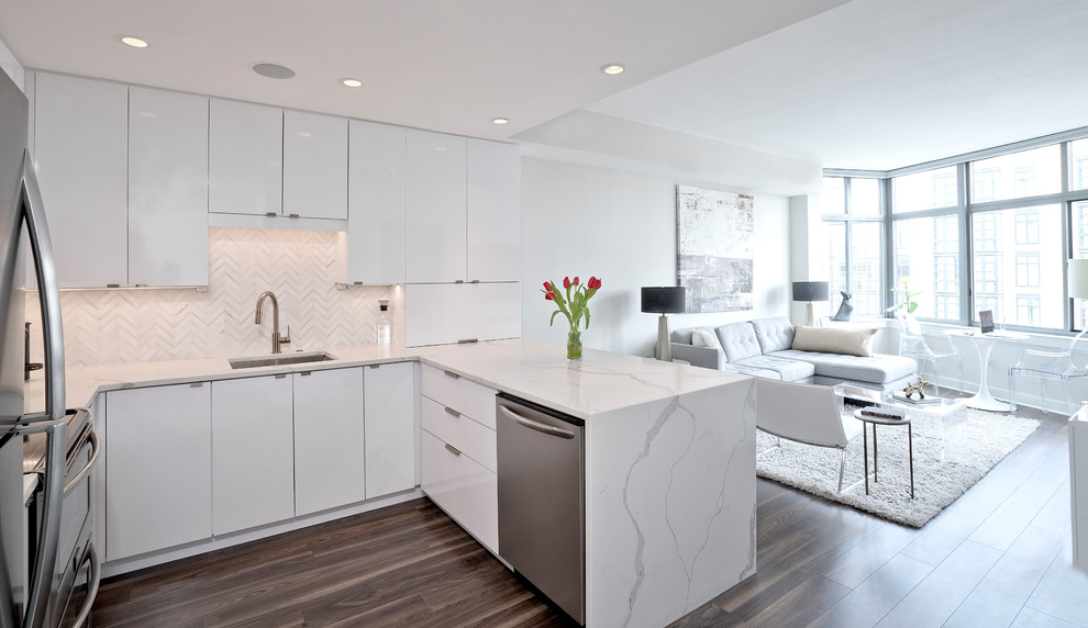 Design ideas for a modern single-wall eat-in kitchen in DC Metro with an undermount sink, flat-panel cabinets, white cabinets, quartz benchtops, white splashback, stainless steel appliances, dark hardwood floors, a peninsula, brown floor and white benchtop.