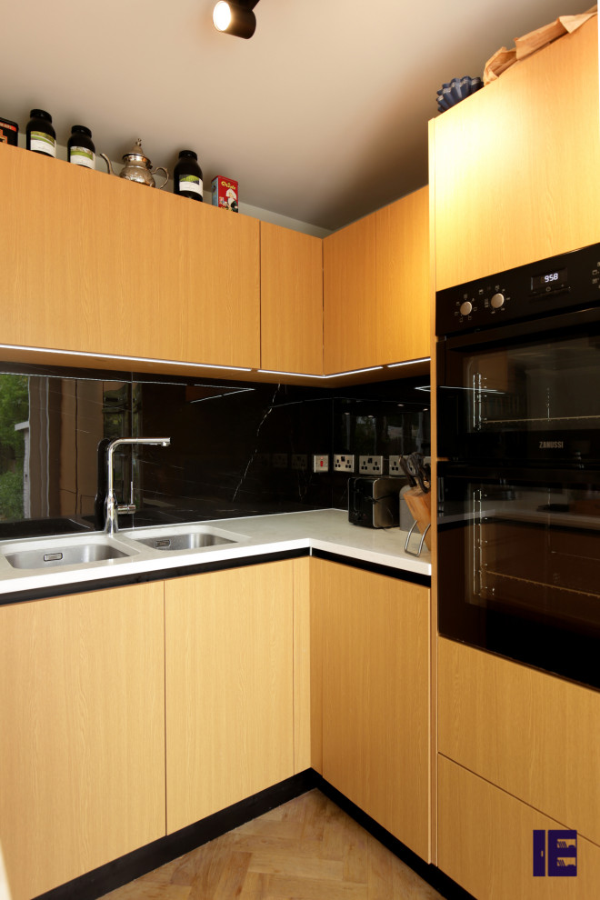 Immagine di una piccola cucina design con lavello a vasca singola, top in quarzite, paraspruzzi arancione e top bianco
