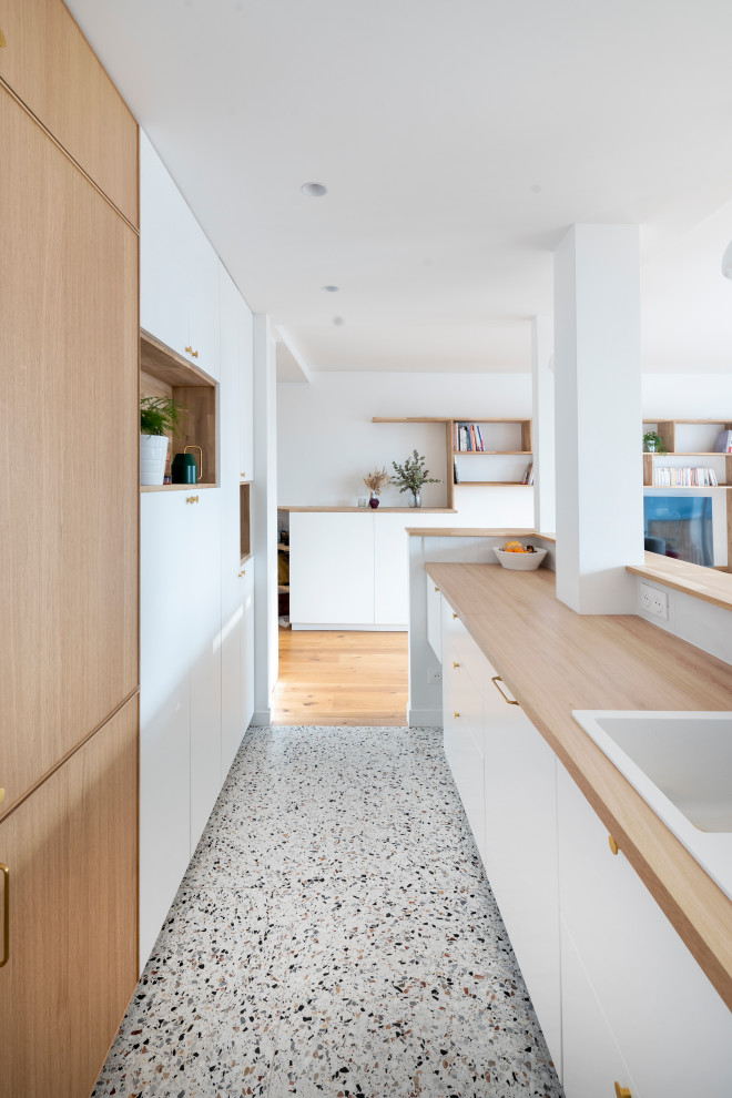 Immagine di una piccola cucina lineare scandinava con lavello da incasso, ante a filo, ante bianche, top in legno, paraspruzzi bianco, paraspruzzi con piastrelle in ceramica e pavimento alla veneziana