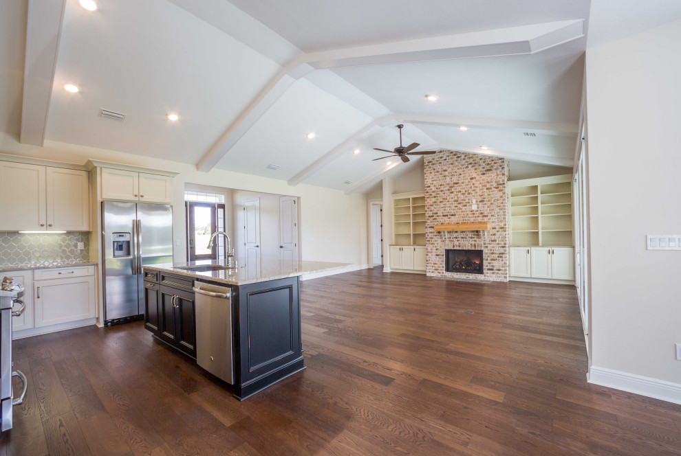 Example of a mid-sized classic galley medium tone wood floor and brown floor eat-in kitchen design with an undermount sink, recessed-panel cabinets, white cabinets, granite countertops, green backsplash, glass tile backsplash, stainless steel appliances, an island and multicolored countertops