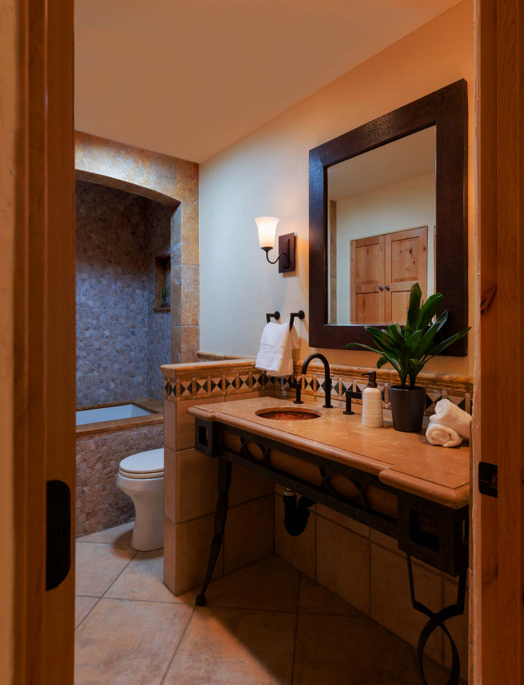 Example of a mid-sized minimalist beige tile and porcelain tile powder room design in Los Angeles with beige cabinets, a one-piece toilet, an undermount sink, limestone countertops, beige countertops and a freestanding vanity
