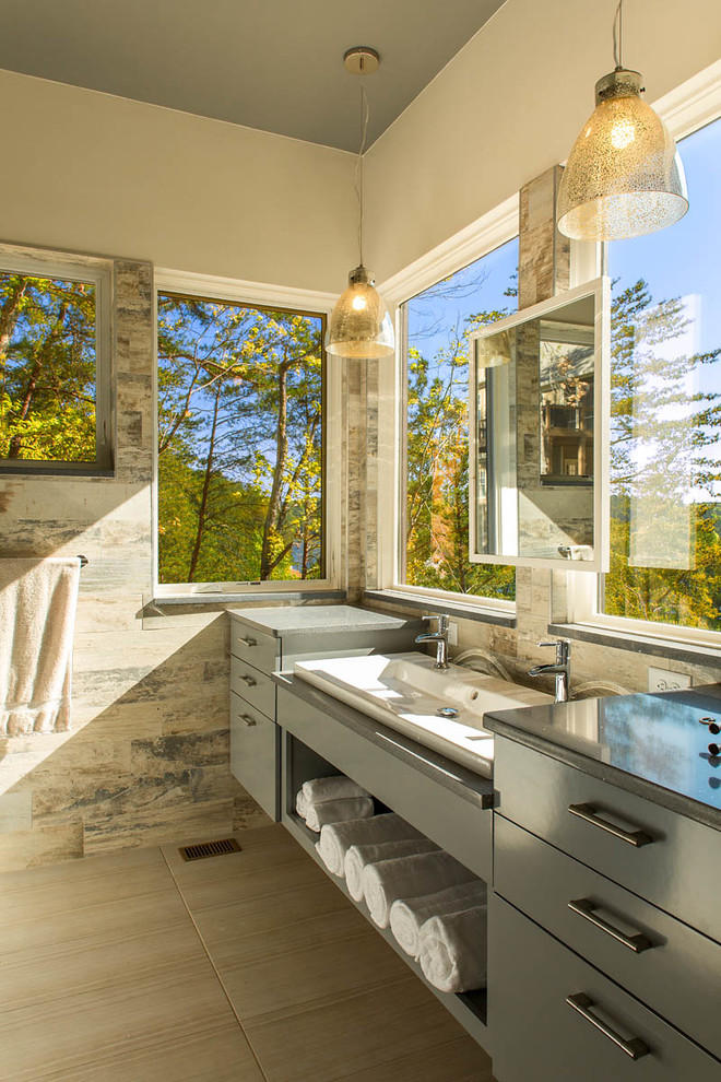 This is an example of a country bathroom in Atlanta with a trough sink, flat-panel cabinets, grey cabinets, beige tile, beige walls and grey benchtops.