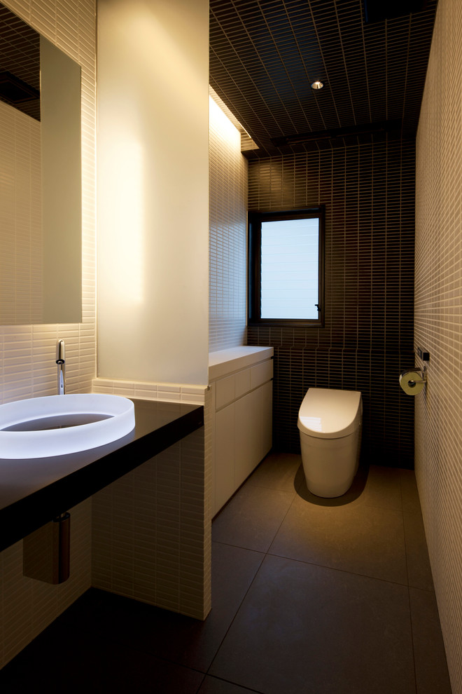 Photo of a large modern powder room in Other with ceramic floors, solid surface benchtops, grey floor, white benchtops, multi-coloured walls and a vessel sink.
