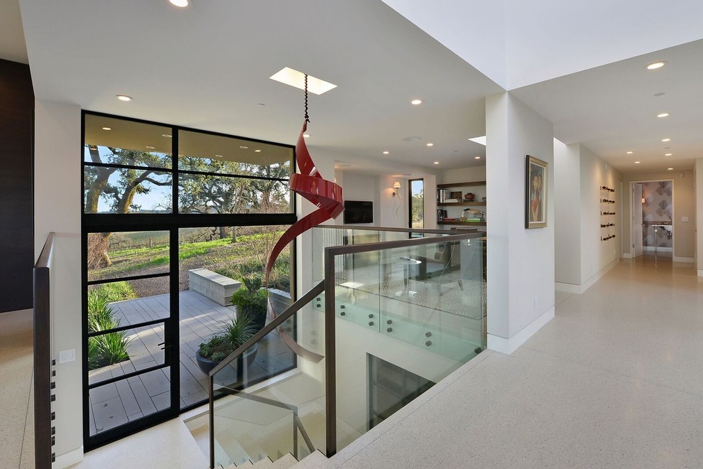 Large contemporary l-shaped staircase in Austin with glass risers and metal railing.