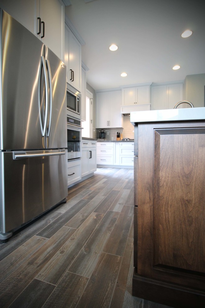 Mid-sized transitional l-shaped porcelain tile open concept kitchen photo in Sacramento with an undermount sink, shaker cabinets, gray cabinets, quartzite countertops, gray backsplash, ceramic backsplash, stainless steel appliances and an island