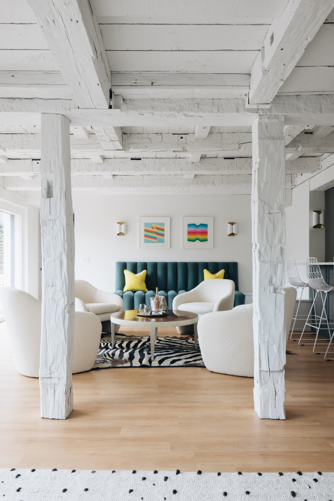 Photo of a large eclectic open concept living room in Grand Rapids with white walls, light hardwood floors and exposed beam.