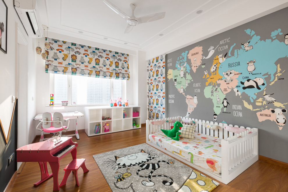 Immagine di una cameretta per bambini da 1 a 3 anni contemporanea con pareti multicolore, pavimento in legno massello medio, pavimento marrone e carta da parati