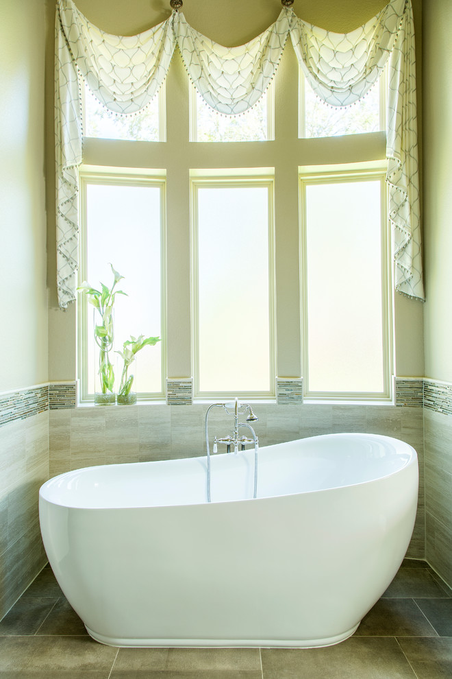 This is an example of a mid-sized transitional master bathroom in Other with a freestanding tub, a one-piece toilet, beige tile, mosaic tile, beige walls, porcelain floors, an undermount sink, blue floor and a single vanity.