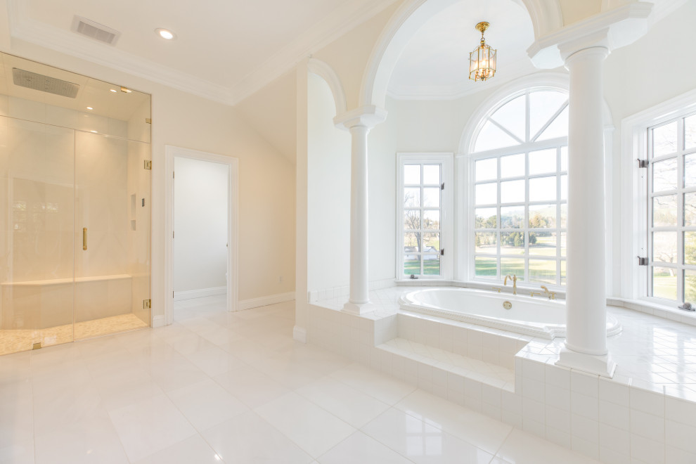 サンフランシスコにある広いコンテンポラリースタイルのおしゃれなマスターバスルーム (インセット扉のキャビネット、白いキャビネット、ドロップイン型浴槽、バリアフリー、ビデ、白いタイル、大理石タイル、白い壁、大理石の床、壁付け型シンク、大理石の洗面台、白い床、開き戸のシャワー、白い洗面カウンター、シャワーベンチ、洗面台2つ、独立型洗面台) の写真