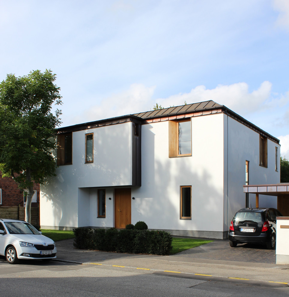 Cette photo montre une grande façade de maison blanche en briques peintes à un étage avec un toit de Gambrel, un toit en métal et un toit marron.