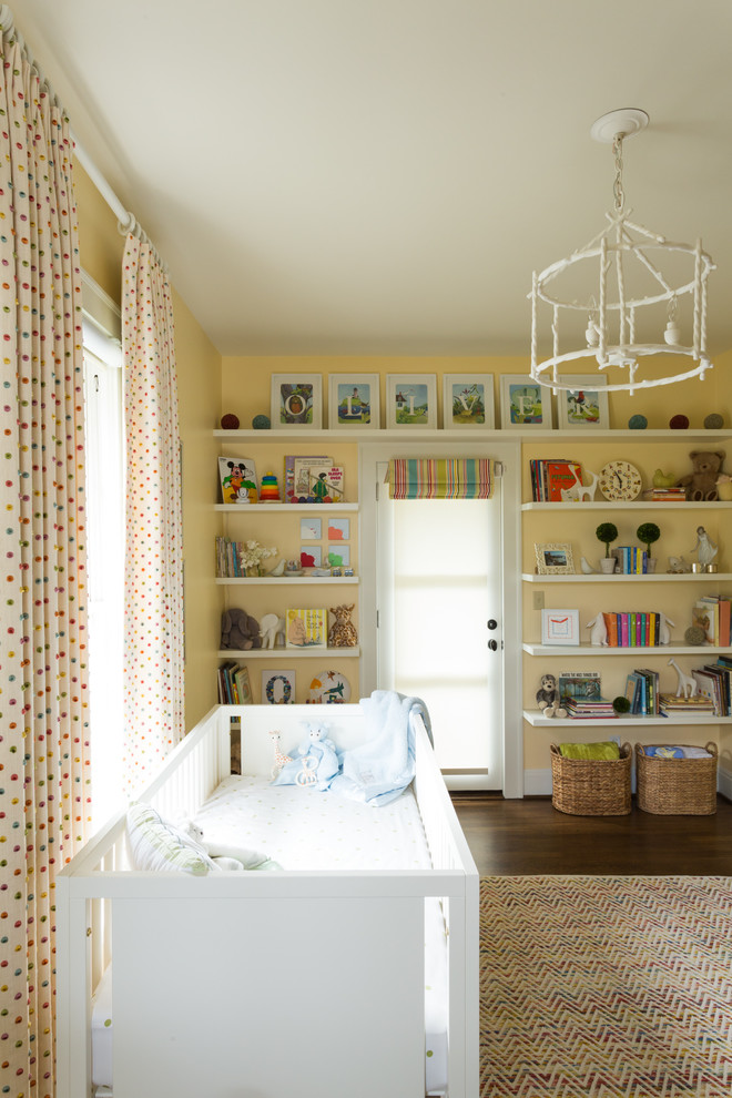 Photo of a large transitional gender-neutral nursery in Portland with yellow walls and dark hardwood floors.