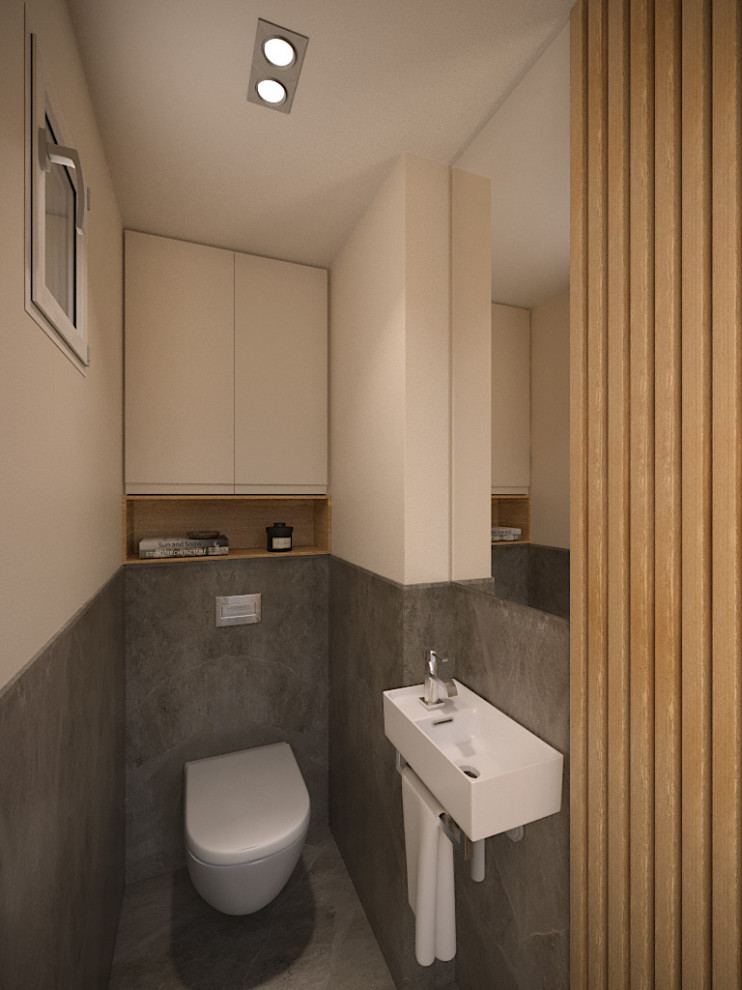 Photo of a small mediterranean cloakroom in Nice with beaded cabinets, beige cabinets, a wall mounted toilet, grey tiles, ceramic tiles, white walls, ceramic flooring, a wall-mounted sink, solid surface worktops, grey floors, white worktops and a built in vanity unit.