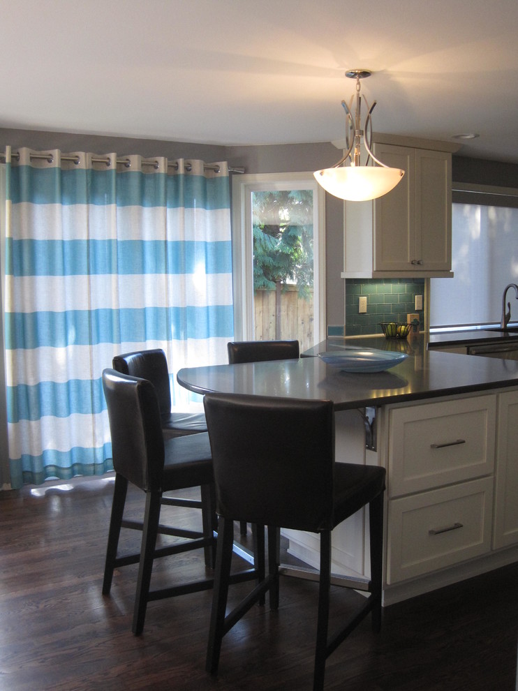 Inspiration for a mid-sized transitional u-shaped dark wood floor home design remodel in Seattle with an undermount sink, shaker cabinets, white cabinets, quartz countertops, blue backsplash, glass tile backsplash, stainless steel appliances and a peninsula