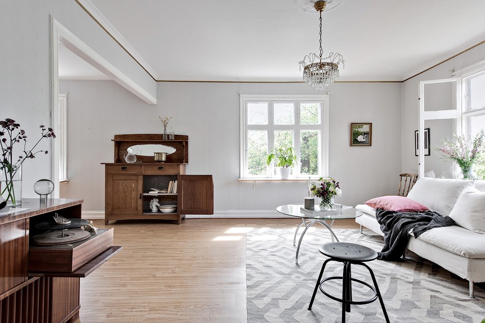 This is an example of a scandinavian living room in Gothenburg with grey walls, light hardwood floors and brown floor.