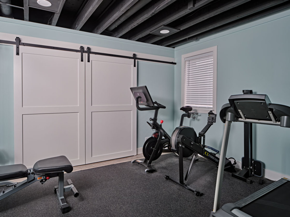 Esempio di una sala pesi minimal di medie dimensioni con pareti blu, moquette, pavimento grigio e travi a vista