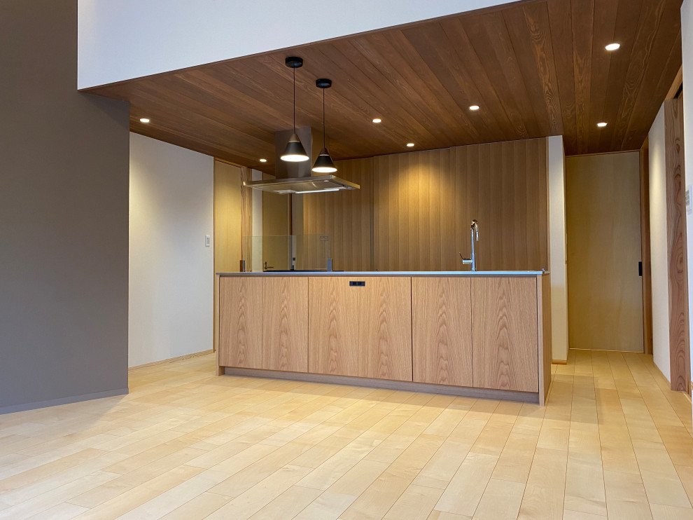 Photo of a mid-sized modern single-wall eat-in kitchen in Other with an undermount sink, beaded inset cabinets, medium wood cabinets, stainless steel benchtops, black appliances, plywood floors, with island, beige floor, beige benchtop and timber.
