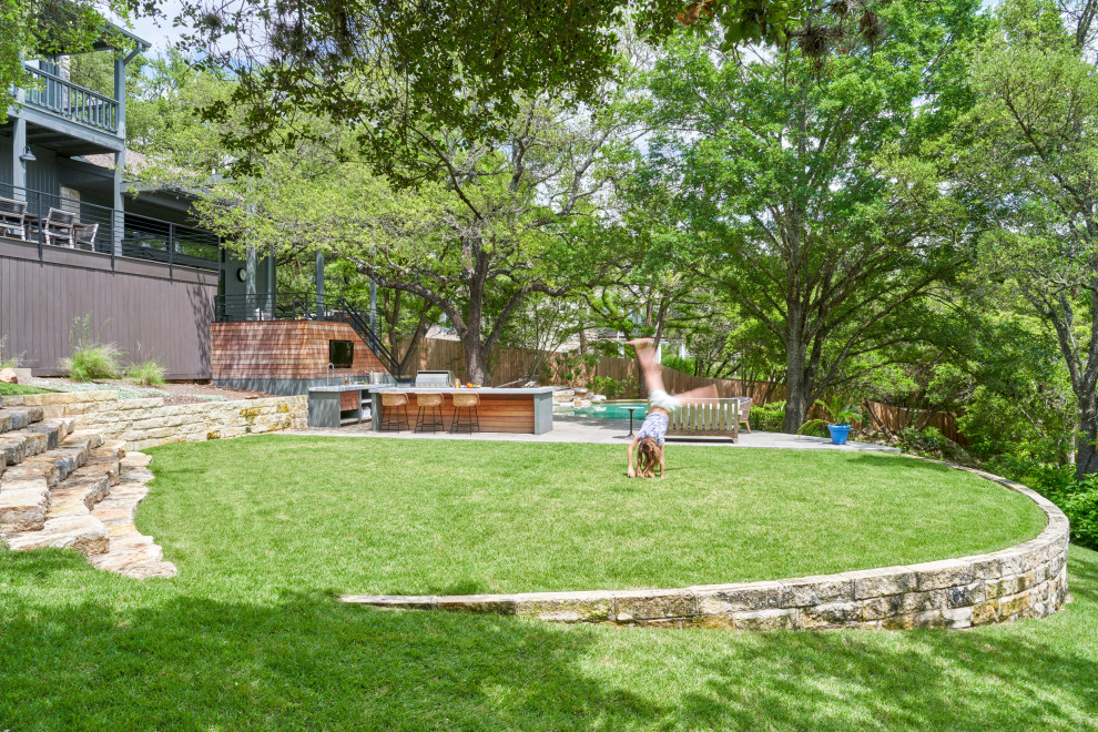 Mittelgroße Moderne Gartenmauer hinter dem Haus mit direkter Sonneneinstrahlung in Austin