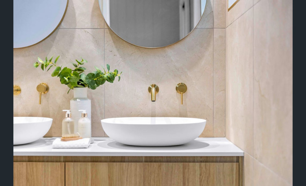 Design ideas for a mid-sized beach style master bathroom in Sunshine Coast with flat-panel cabinets, light wood cabinets, an open shower, a one-piece toilet, beige tile, porcelain tile, beige walls, porcelain floors, a vessel sink, engineered quartz benchtops, white benchtops, a double vanity and a floating vanity.