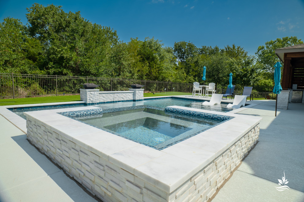 Large modern back rectangular natural swimming pool in Dallas with with pool landscaping and decking.