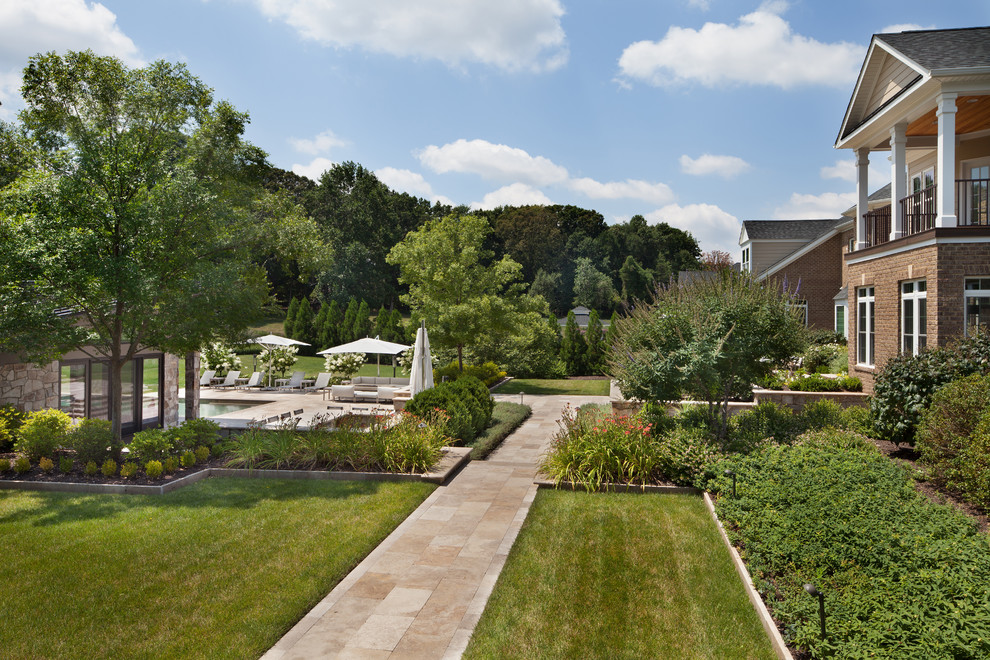 Large traditional backyard full sun garden in DC Metro with natural stone pavers.