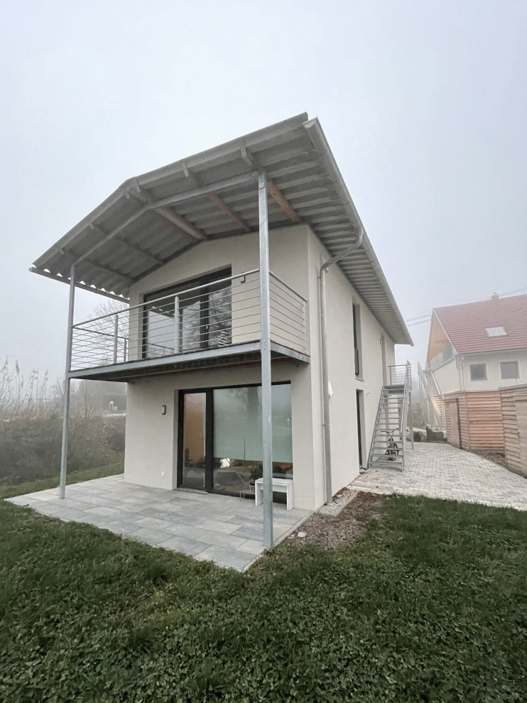 Kleines, Zweistöckiges Modernes Wohnung mit Putzfassade, weißer Fassadenfarbe, Satteldach, Blechdach und grauem Dach in München