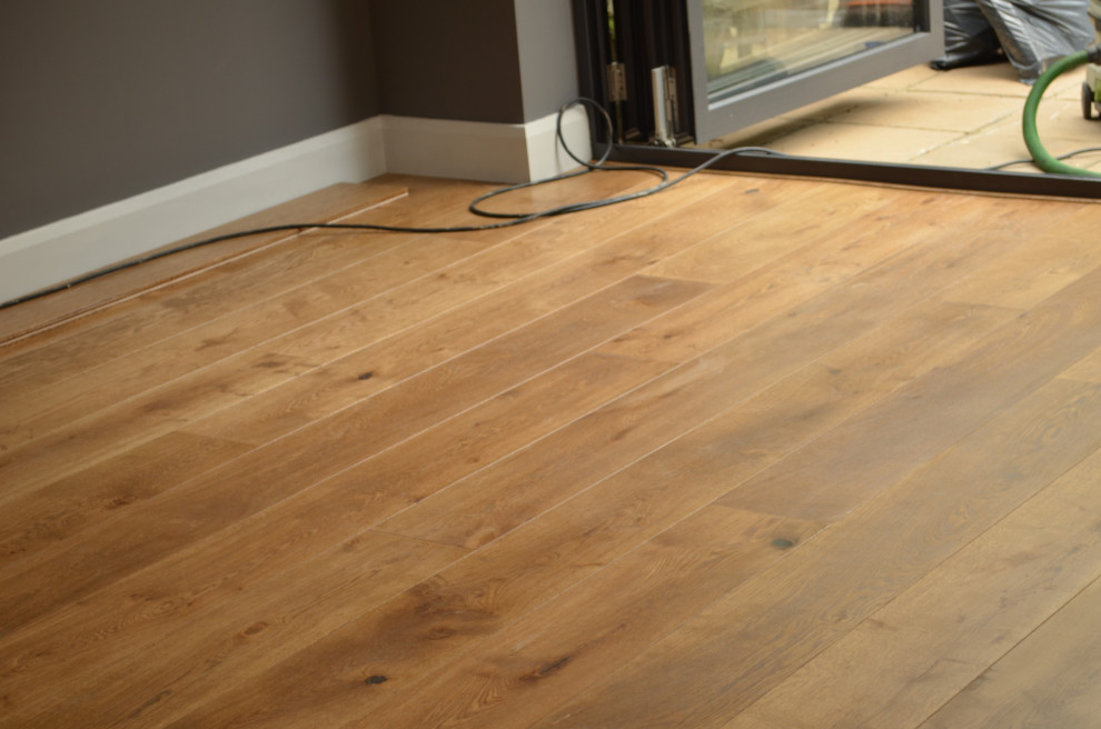 Foto di un soggiorno design con pavimento in legno massello medio e pavimento marrone