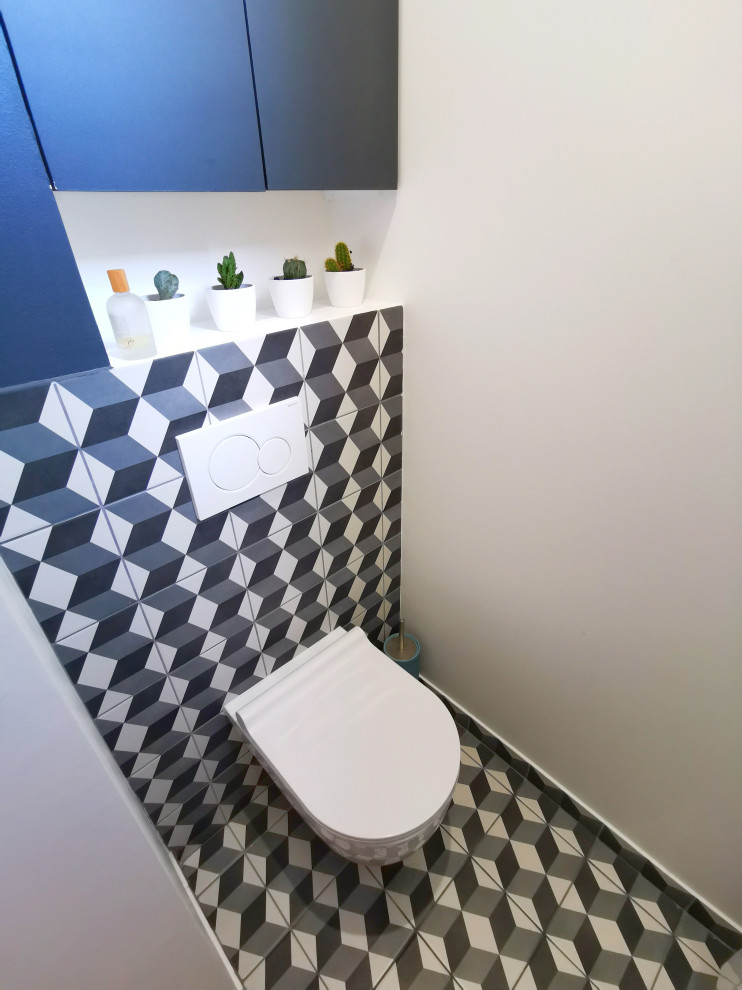 Exempel på ett litet modernt flerfärgad flerfärgat toalett, med släta luckor, blå skåp, en vägghängd toalettstol, vita väggar, klinkergolv i keramik, kaklad bänkskiva och flerfärgat golv