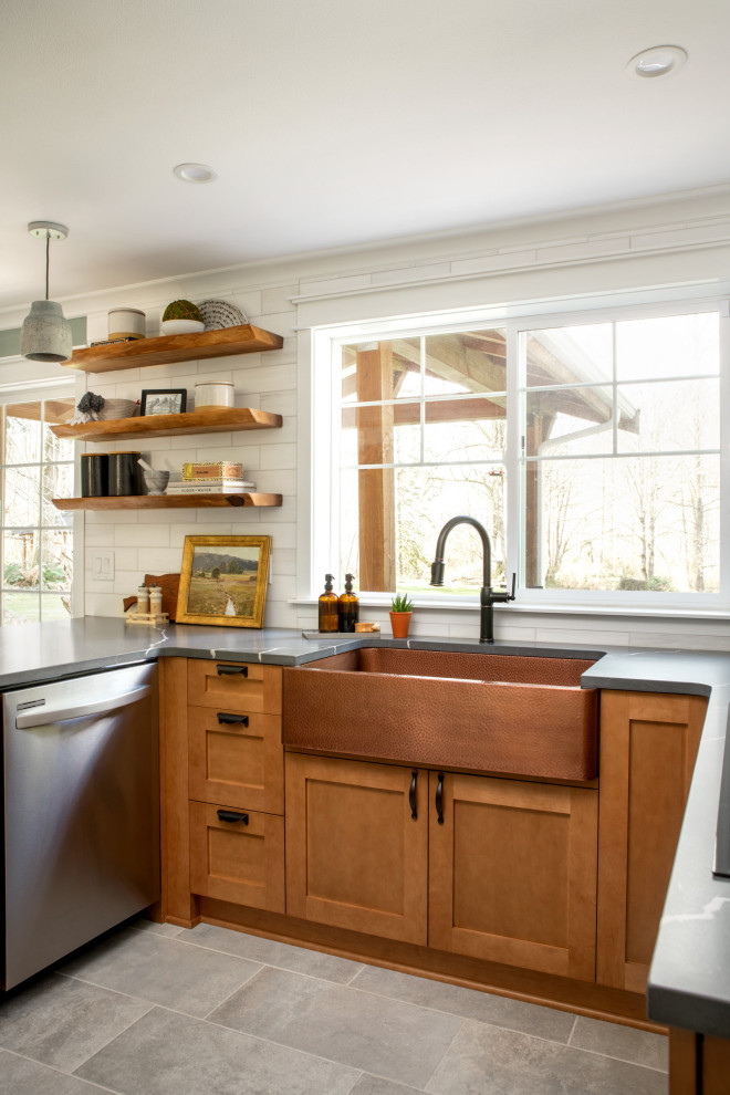 Inspiration for a mid-sized arts and crafts u-shaped eat-in kitchen in Seattle with a farmhouse sink, shaker cabinets, medium wood cabinets, quartz benchtops, white splashback, marble splashback, stainless steel appliances, ceramic floors, a peninsula, grey floor and grey benchtop.