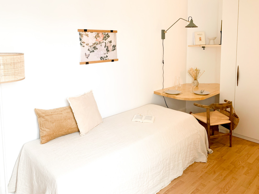 На фото: маленькая гостиная комната в современном стиле с полом из ламината для на участке и в саду