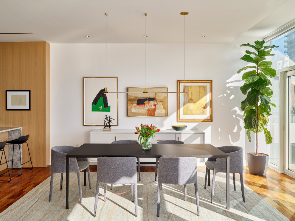 Ispirazione per una piccola sala da pranzo aperta verso la cucina minimal con pareti bianche e pavimento in legno massello medio