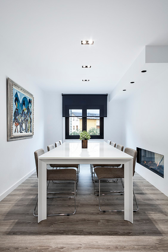 Foto de comedor nórdico de tamaño medio cerrado sin chimenea con paredes blancas y suelo de madera en tonos medios