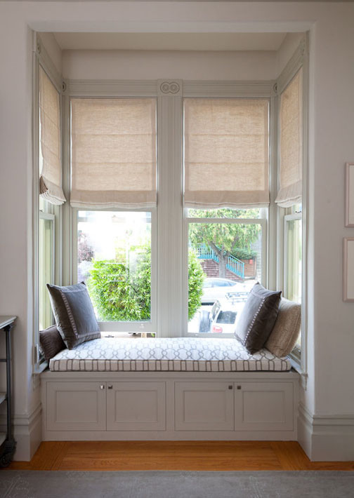 Motorized Roman Shades in a bay window and built in window seat